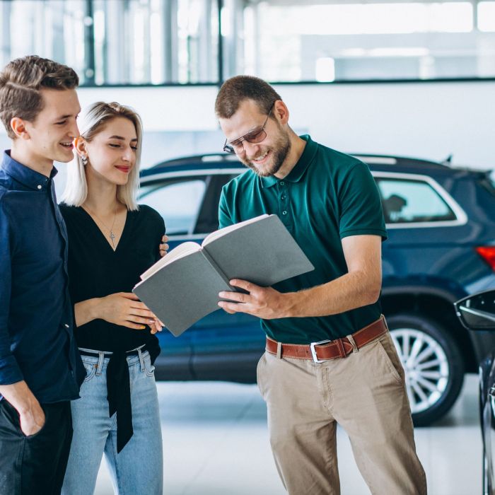 Young family buying a car in a car showroom